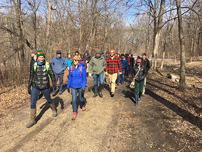 Managers and scientists exploring a floodplain forest along the Mississippi River Basin